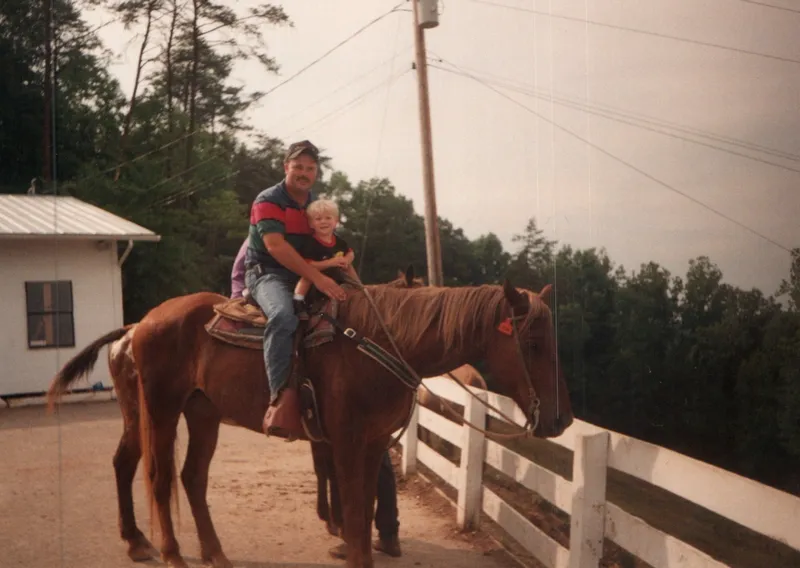 Brian King on horseback holding a young Ryan
