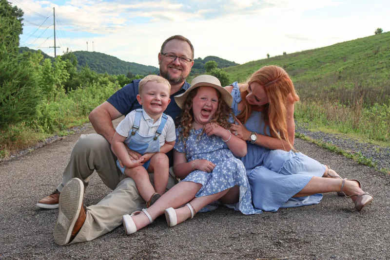 Ryan, Brittany, Kinsley and Kamden sitting on a path and laughing